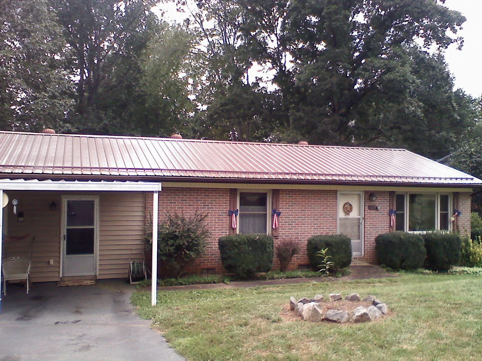 Bronze metal roof and carport on a brick ranch home — Roof Repair work by our crew in Lafayette